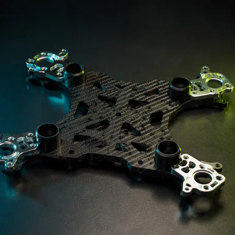 Professional studio photograph of a modular carbon fiber UAV airframe centre plate with four boom sockets and machined aluminium motor mounts resting on a dark surface, visible carbon weave and chamfered edges, teal and lime green rim lighting, shallow depth of field, photorealistic, no people faces, no text, no logos