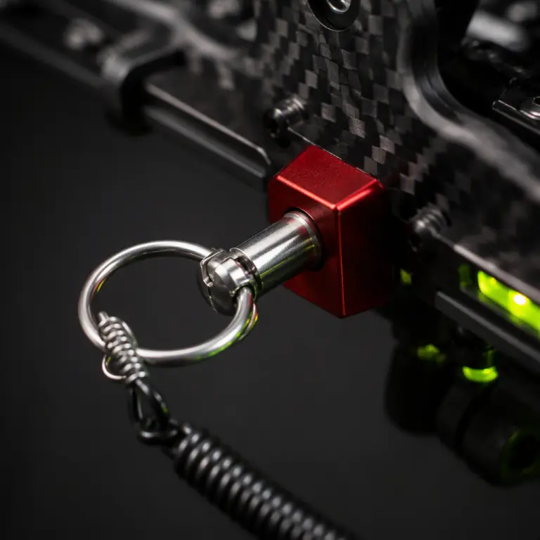 Extreme macro photograph of a stainless steel safety pull-pin tethered by a coiled lanyard, inserted into a small red-anodized arming block on a UAV payload hardpoint, carbon fiber surface visible behind, dark studio background, lime-green accent glow, photorealistic, no people faces, no text, no logos